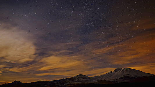 snow-covered mountain under cloudy sky during nighttime thumbnail