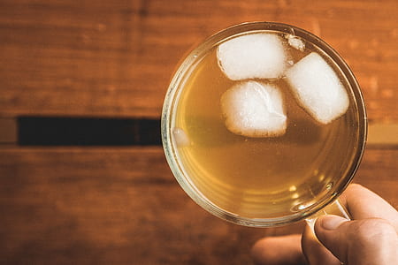 person holding clear glass mug with ice thumbnail