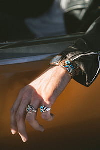 person in black leather jacket wearing two silver-colored rings thumbnail