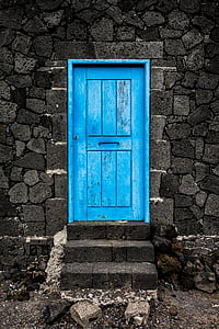 blue wooden door on gray concrete structure thumbnail