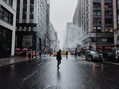 people walking on road surrounded by high-rise buildings thumbnail