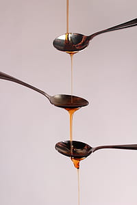 three stainless steel spoons with honey thumbnail