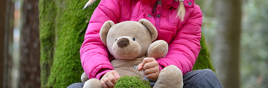 shallow focus photography of person holding bear plush toy thumbnail