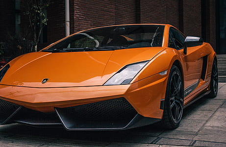 Side view of orange lamborghini with projector headlights and alloy wheels thumbnail
