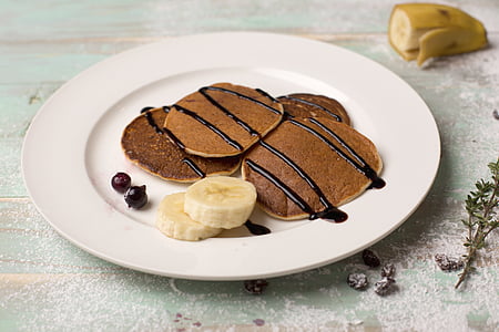 plate of pancakes with chocolate syrup and sliced banana thumbnail