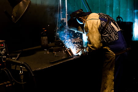 man welding black metal thumbnail