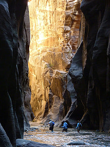 photo of three persons walking beside rock mountain thumbnail