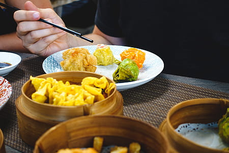 Eating Chinese steamed and fried dim sum with chopsticks thumbnail
