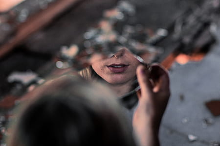 woman holding broken piece of glass thumbnail