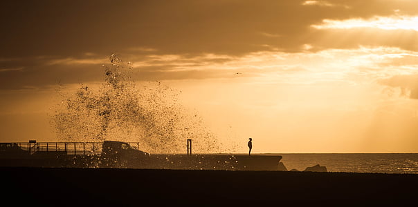 silhouette of a person standing bridge beside sea illustration thumbnail