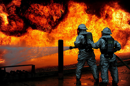 two firefighters holding hose towards fire thumbnail
