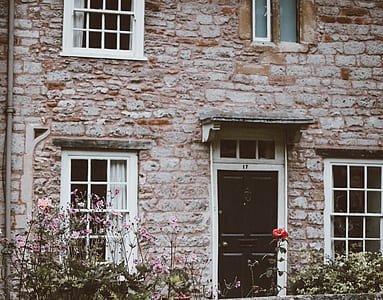 bricked walled house with closed brown wooden door thumbnail