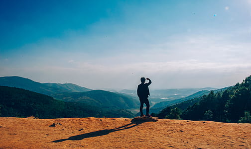 Silhouette of Man Standing on Mountain Cliff thumbnail