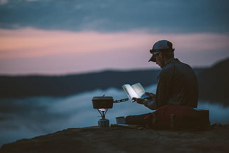 man wearing gray hat seating on top of mountain during sunset thumbnail
