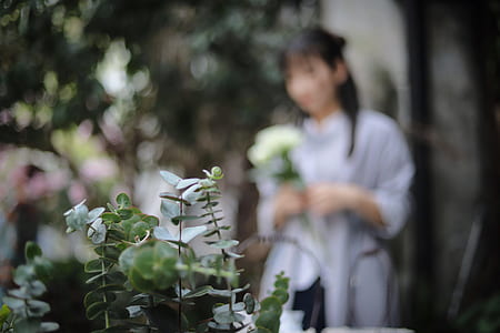 woman standing in front of green leafed plants thumbnail