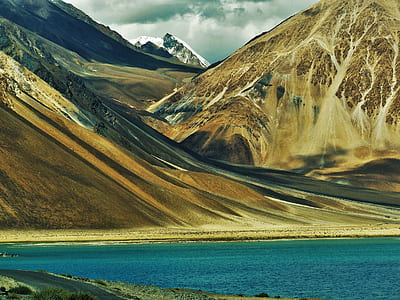 brown mountain near body of water thumbnail