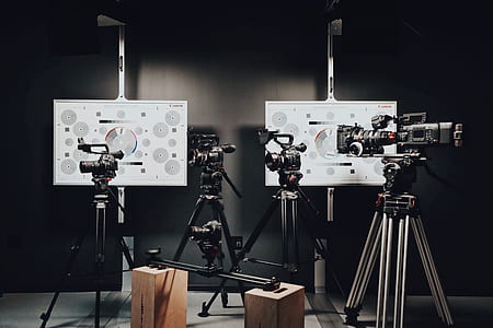 four assorted black video recorders with tripods thumbnail