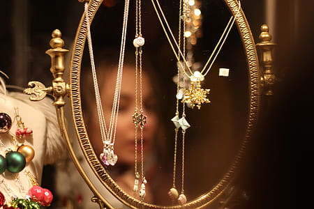 round gold-colored framed mirror with hanged assorted pendant necklaces thumbnail