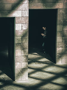 man standing leaning on wall on focus photo thumbnail