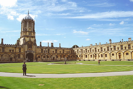 man standing on pathway near brown concrete building at daytime thumbnail
