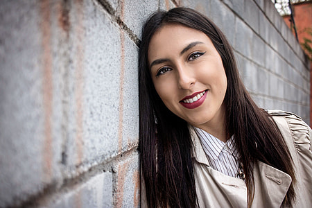 smiling woman leaning on wall thumbnail