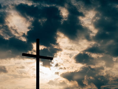 silhouette photo of wooden cross under gray cloudy sky thumbnail