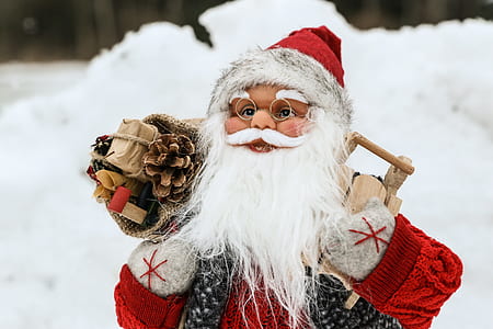 close-up photo of Santa Clause figurine in the snow thumbnail