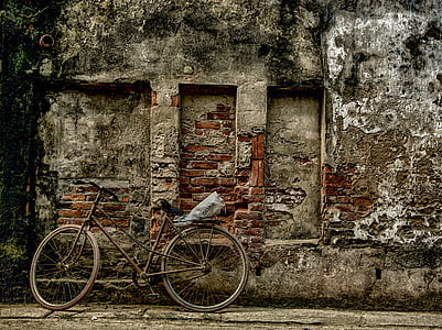 brown and grey bicycle parked near brown concrete building thumbnail