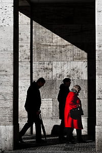 two men and one woman walking on street during daytime thumbnail