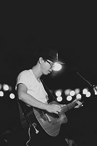 grayscale photo of man playing acoustic guitar thumbnail
