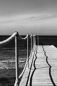 grayscale photography of dock across sea thumbnail