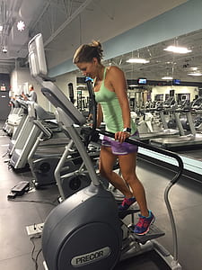 woman in green tank top using Precor exercise equipment thumbnail