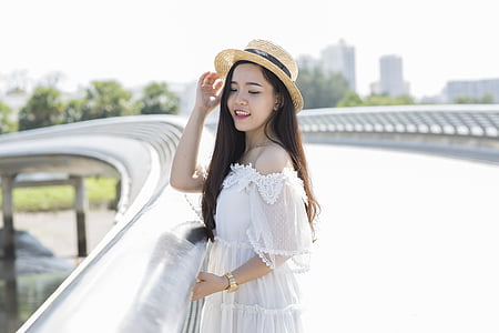 women wearing white off-shoulder shirt and brown hat thumbnail