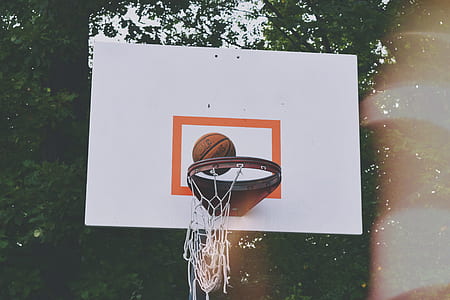 time lapse photography of basketball about to fall on basketball ring thumbnail