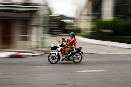 panning photography of woman driving motorcycle at daytime thumbnail