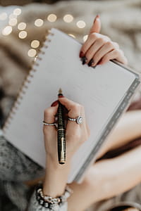 Writing in a notebook lying in bed, with coffee, candles, and gingerbreads thumbnail