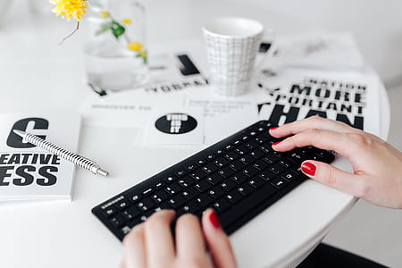 Female hands typing on the remote wireless computer keyboard thumbnail
