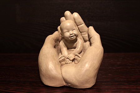 baby on human hand figurine thumbnail