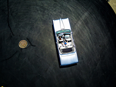 round gold-colored coin near grey vehicle diecast metal scale model thumbnail