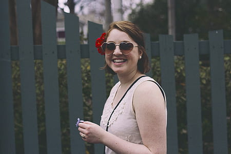 woman smiling near gray wooden fence thumbnail