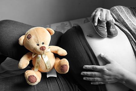 selective color photography of woman lying on bed with a teddy bear on her lap thumbnail