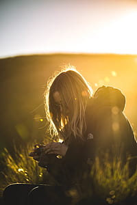 man holding black DSLR camera sitting on green grass ground thumbnail