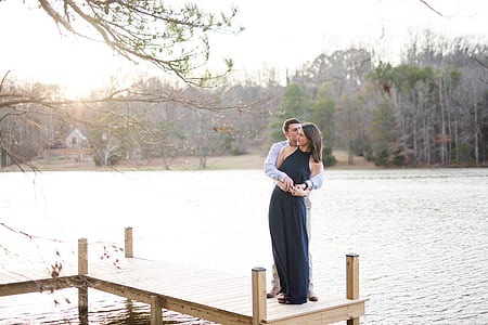 man hugging woman while standing on dock thumbnail