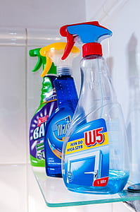 three cleaning spray bottles on top of glass-top wall shelf thumbnail