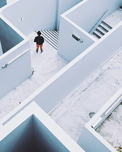 person wearing black top beside white concrete wall thumbnail