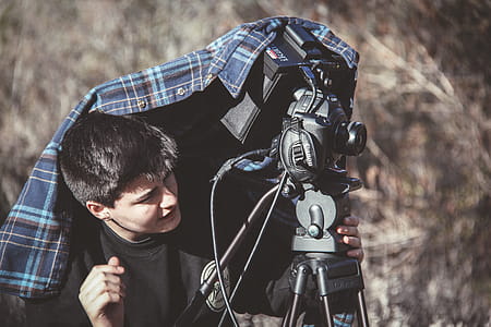 Photo of Man Setting Up Dslr Camera on Tripod thumbnail