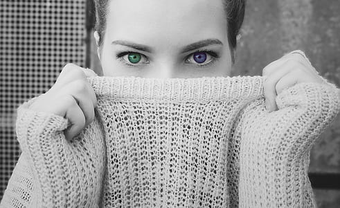 selective-color photography of woman covering mouth with sweater thumbnail
