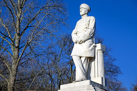 man standing statue beside tree thumbnail