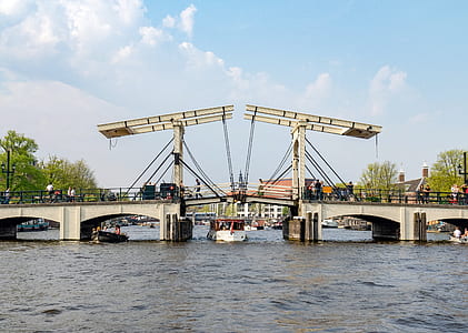 white boat passing under white bridge at daytime thumbnail