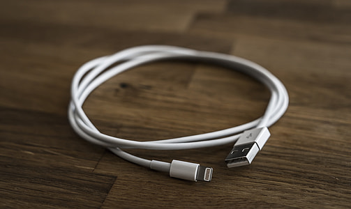 white 8-pin lightning cable on brown wooden board thumbnail